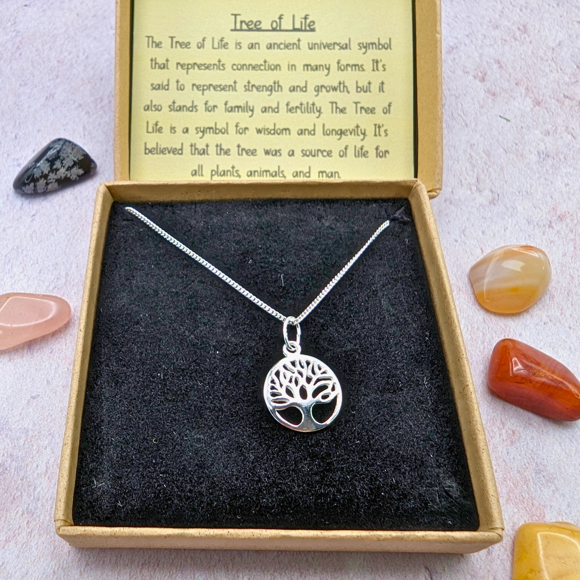 The Silver Sunbird Tree of Life Sterling Silver Necklace comes in a gift box with polished stones and a card explaining the tree’s symbolism—connection, strength, growth, wisdom, and longevity—making it meaningful jewelry for any occasion.