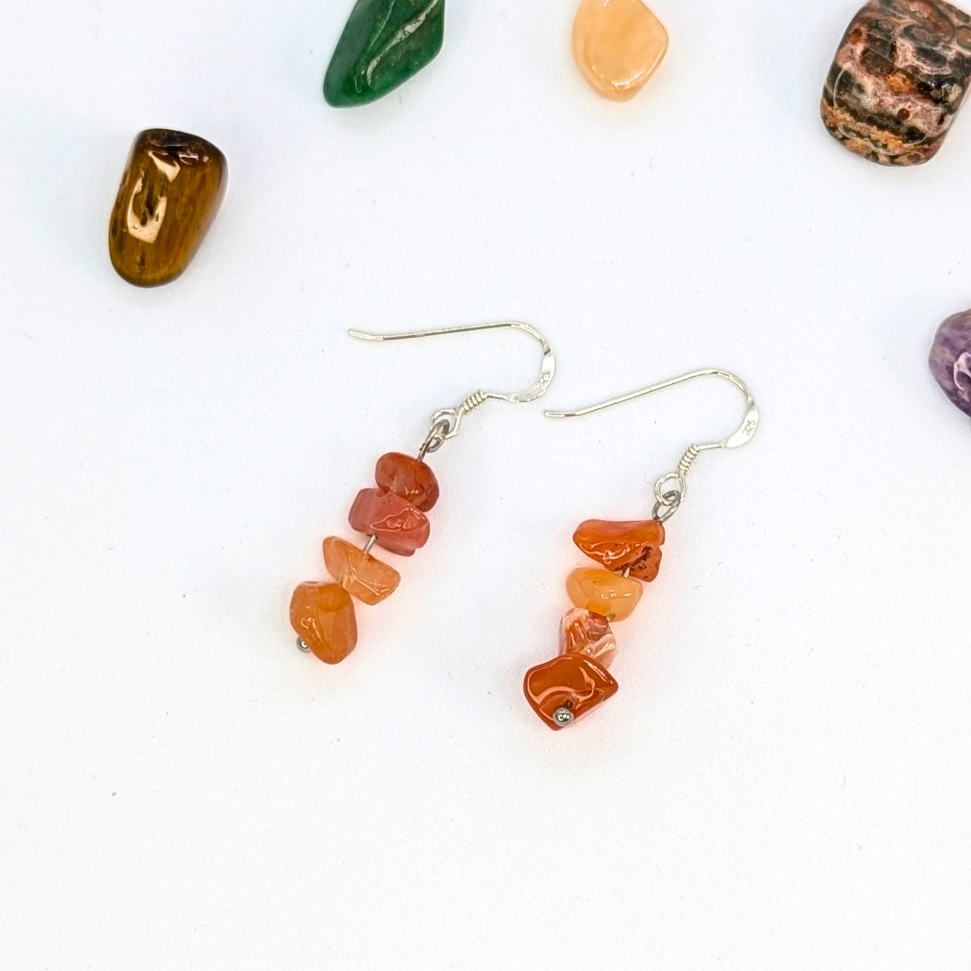 Silver Sunbird’s Carnelian Agate Earrings: sterling silver dangle earrings with stacked orange carnelian chips, shown on a white background with colorful stones—perfect handmade gemstone jewelry.