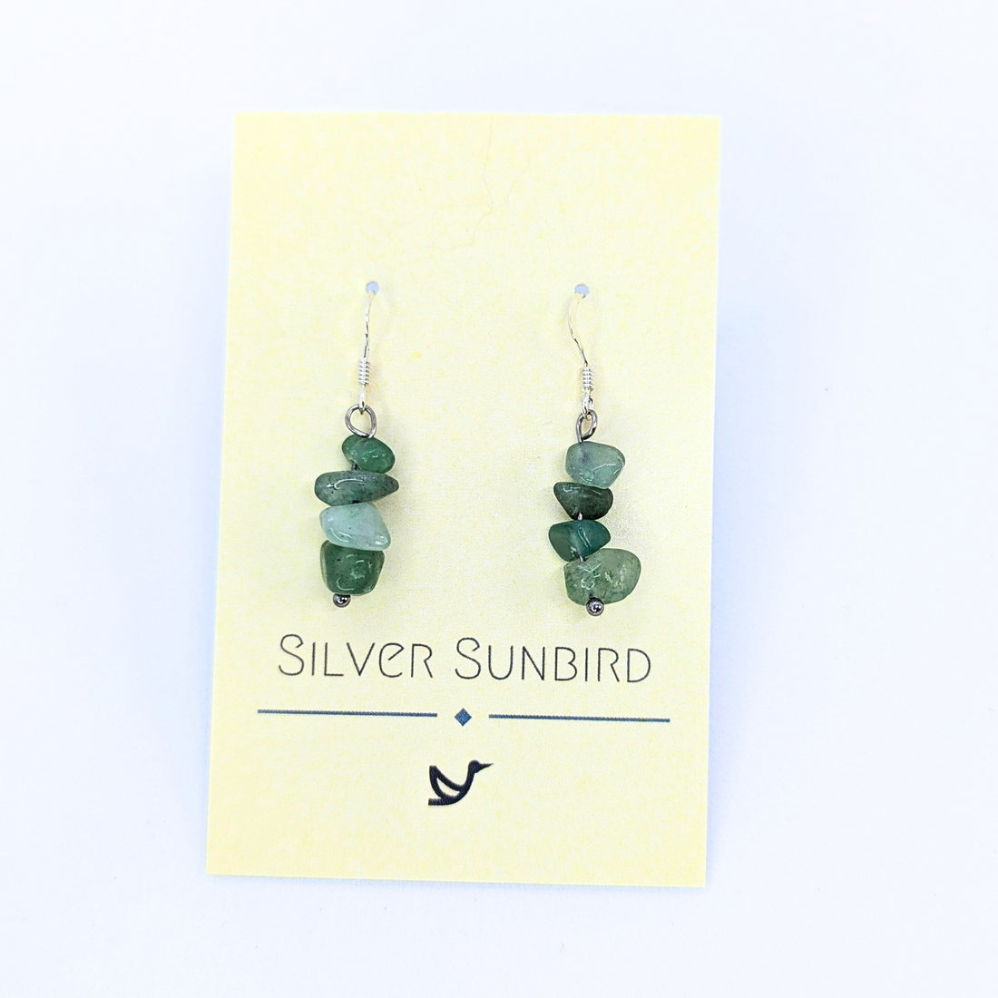 Green Aventurine Earrings by Silver Sunbird feature stacked stone beads and come displayed on a pale yellow branded card with a bird logo—perfect handmade gemstone jewelry for any occasion.