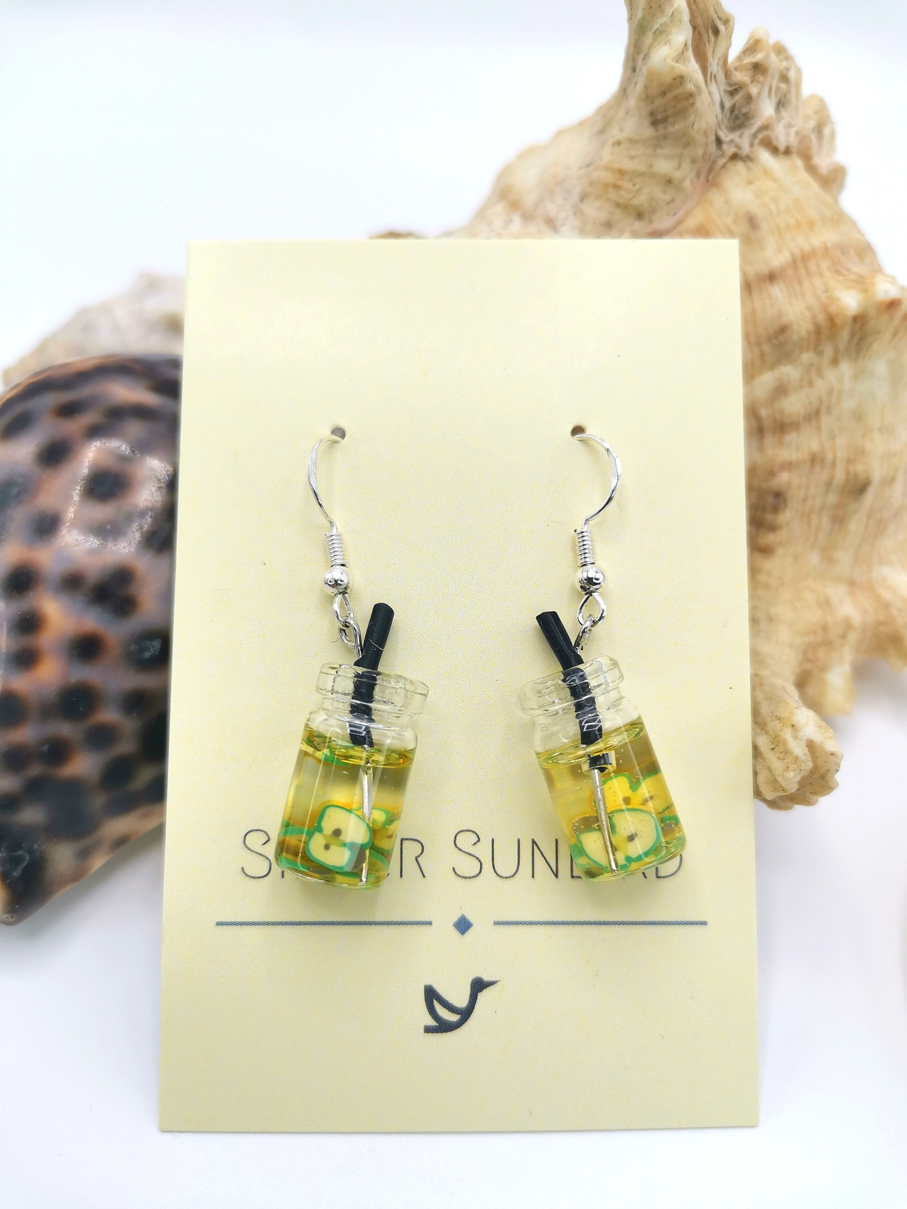 The Party Cocktail Earrings by Silver Sunbird are handmade to resemble miniature bubble tea drinks with green accents. Featuring sterling silver hooks, they&