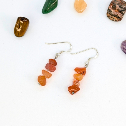 Silver Sunbird’s Carnelian Agate Earrings: sterling silver dangle earrings with stacked orange carnelian chips, shown on a white background with colorful stones—perfect handmade gemstone jewelry.