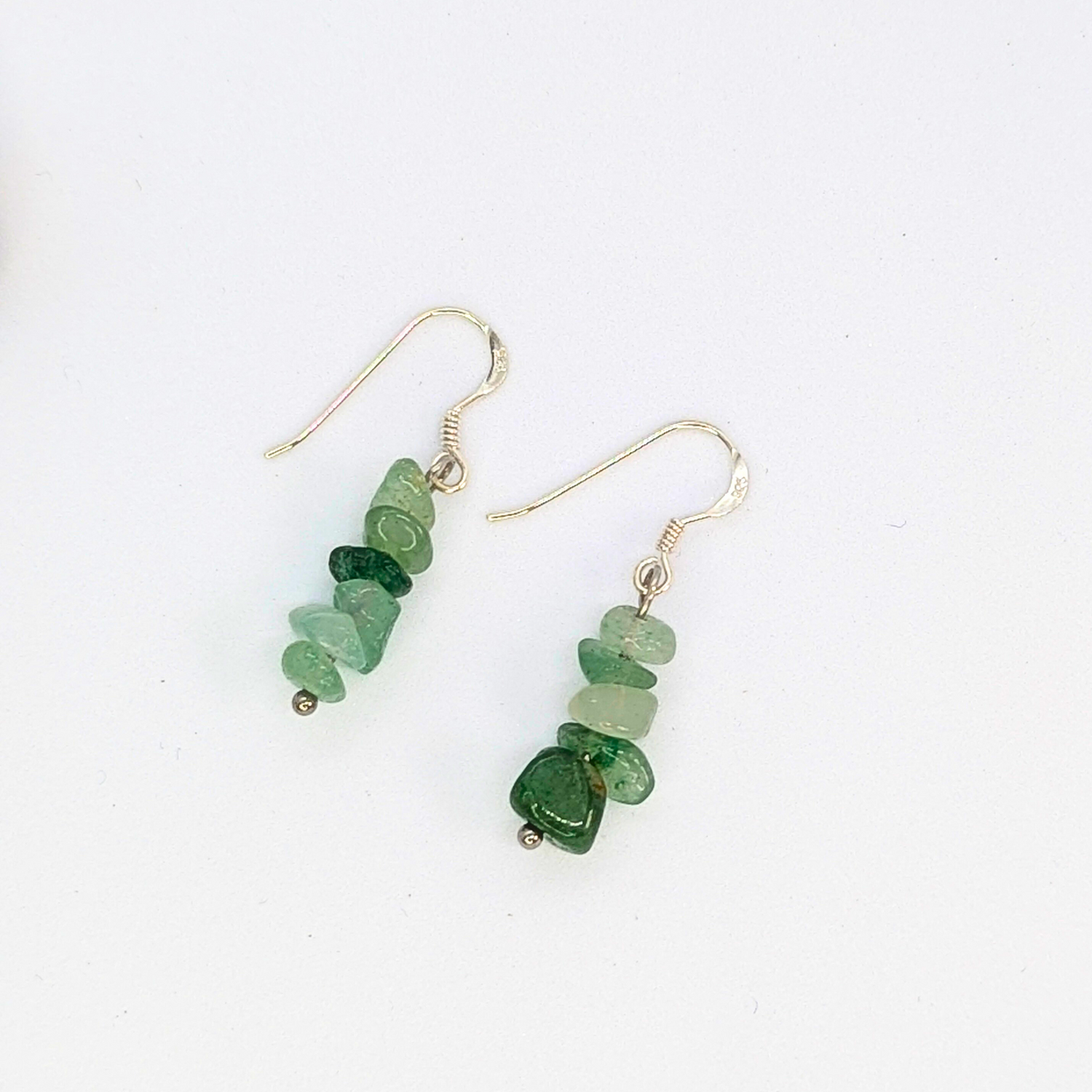 The Silver Sunbird Green Aventurine Earrings feature stacked irregular green aventurine beads on sterling silver hooks, displayed against a white background.