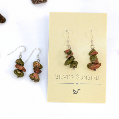 Unakite Gemstone Earrings by Silver Sunbird: handmade dangle earrings with green and reddish-brown Unakite beads, shown both on a branded card and against a white background.